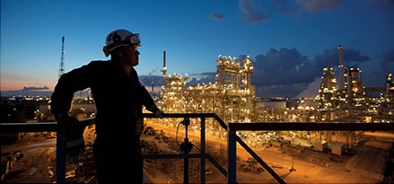 A silhouetted worker leans on a gantry