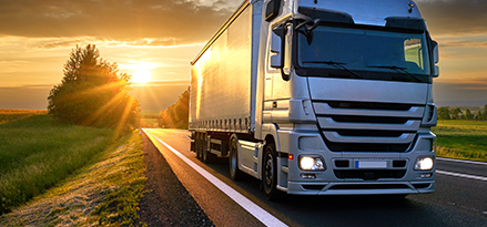 An HGV driving on a road in the sunlight